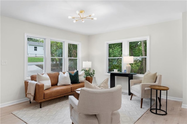 living room with light hardwood / wood-style floors and a notable chandelier