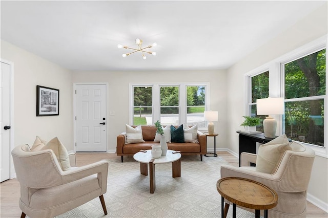 sitting room with a wealth of natural light, a chandelier, and light hardwood / wood-style floors