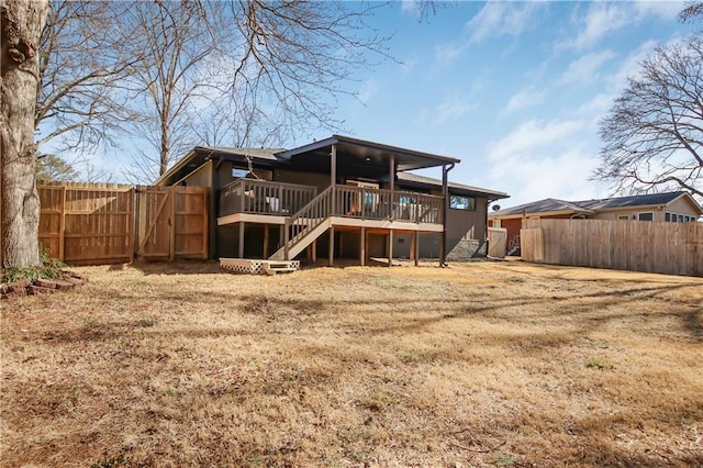 rear view of house featuring a yard and a deck