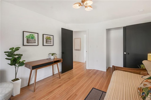 bedroom with a notable chandelier, light hardwood / wood-style floors, and a closet