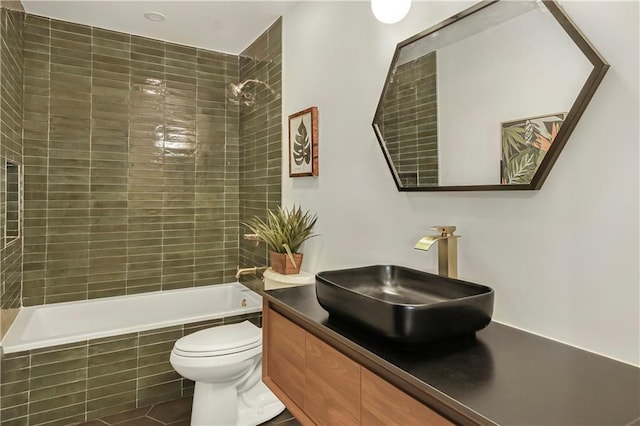 full bathroom featuring tiled shower / bath, vanity, and toilet