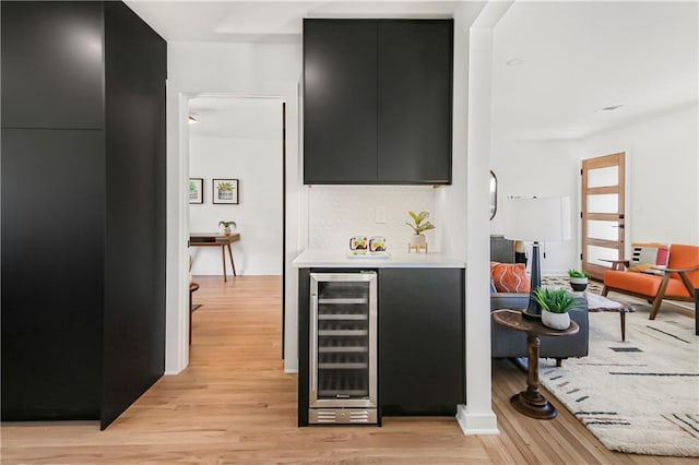 bar featuring wine cooler and light hardwood / wood-style floors