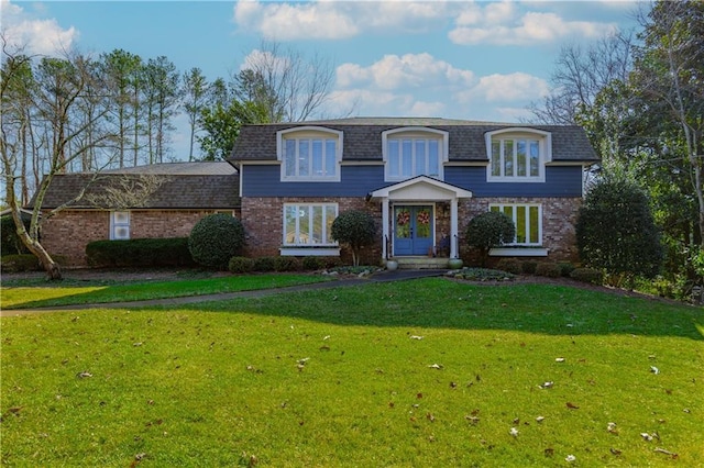 front facade featuring a front yard and french doors