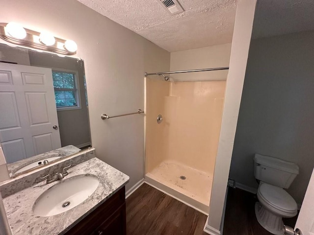 1095 S Burnt Hickory Rd, Douglasville, GA 30134 - bathroom with a textured ceiling, wood finished floors, a shower, vanity, and toilet