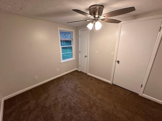 1095 S Burnt Hickory Rd, Douglasville, GA 30134 - unfurnished bedroom with a textured ceiling, dark carpet, baseboards, and a ceiling fan