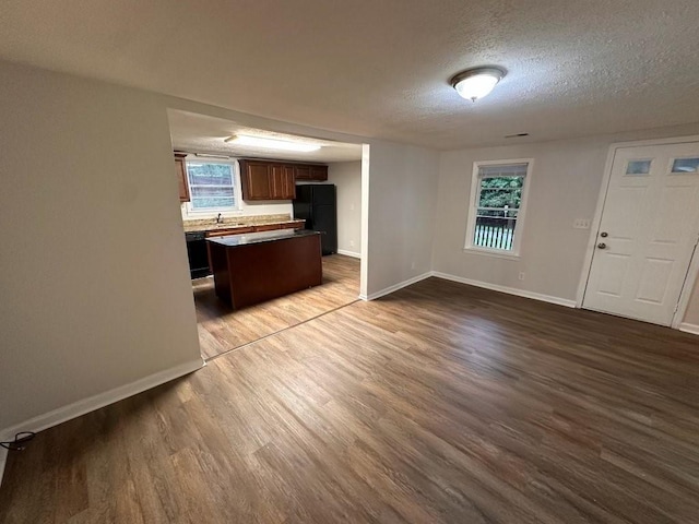 1095 S Burnt Hickory Rd, Douglasville, GA 30134 - kitchen with black appliances, a textured ceiling, baseboards, and wood finished floors