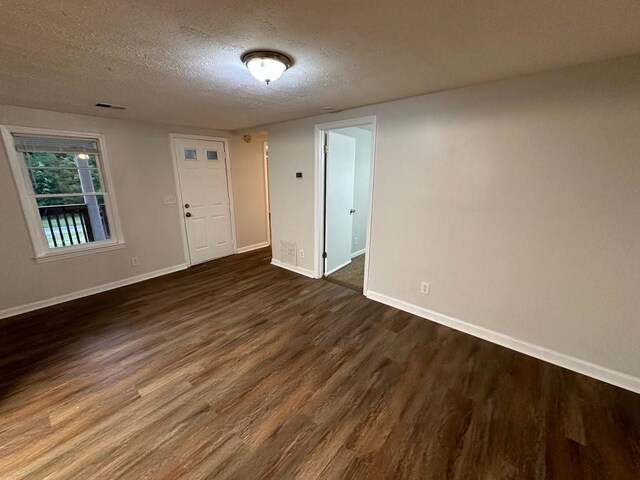 1095 S Burnt Hickory Rd, Douglasville, GA 30134 - unfurnished room featuring dark wood-style flooring, a textured ceiling, and baseboards