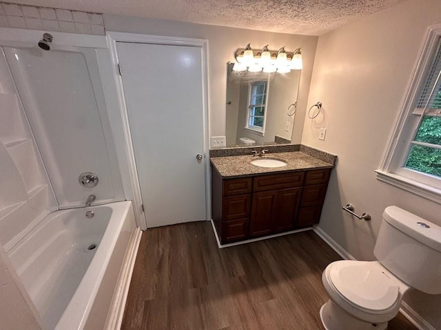 1095 S Burnt Hickory Rd, Douglasville, GA 30134 - full bathroom with wood finished floors, vanity, a textured ceiling, toilet, and shower / bathtub combination
