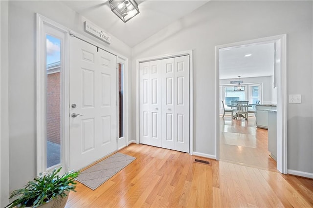 entryway with vaulted ceiling and light wood-type flooring