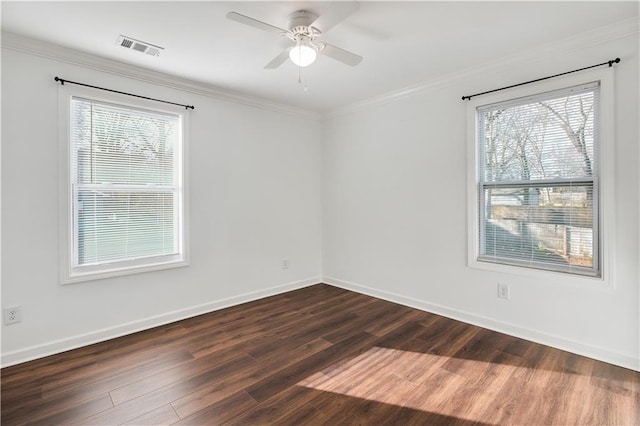 empty room with dark wood-style floors, ornamental molding, visible vents, and baseboards