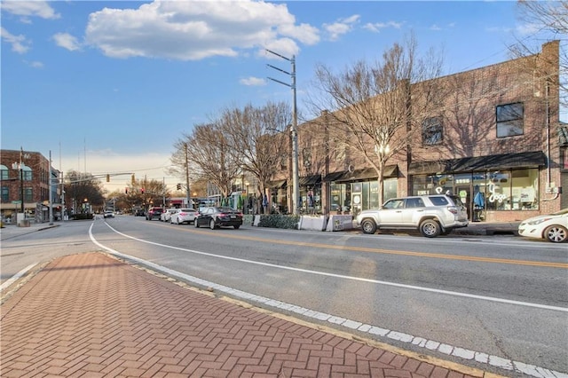 view of road featuring street lights, curbs, and sidewalks