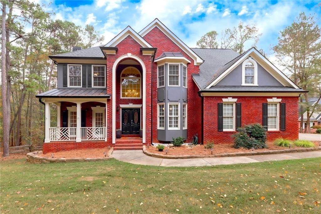 view of front of house with a front yard and covered porch