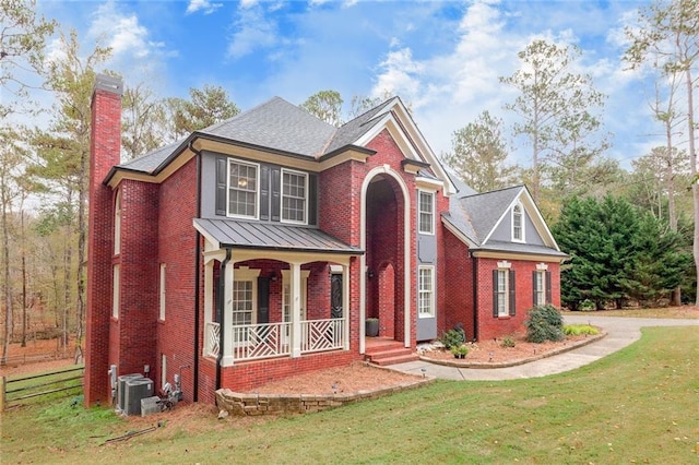 view of front of home with central AC unit, a front yard, and a porch