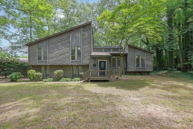 rear view of house featuring a deck and a lawn