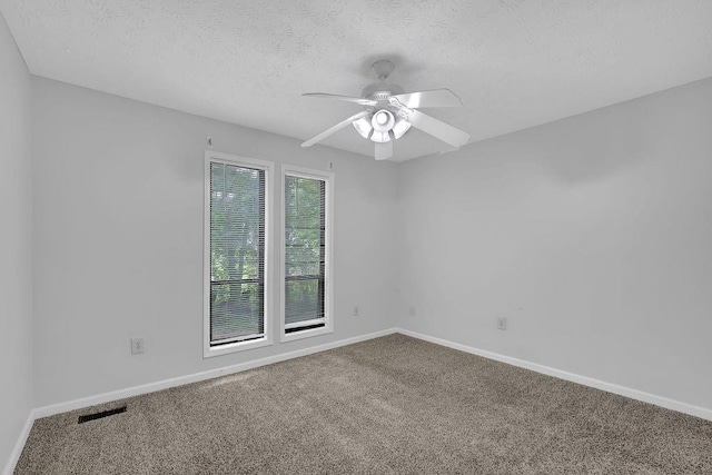 carpeted empty room with a textured ceiling, a ceiling fan, and baseboards