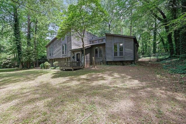 back of property with fence and a wooden deck