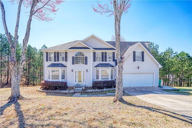 view of front facade featuring an attached garage, driveway, and a front lawn