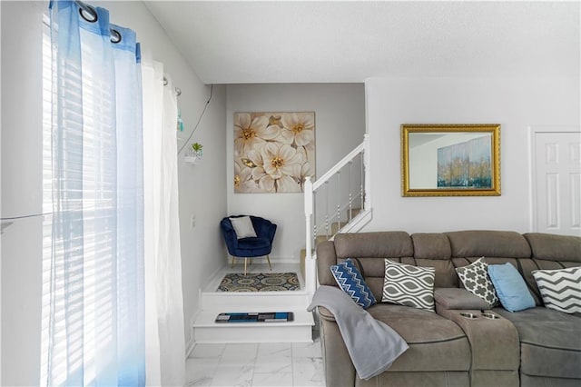 living room with marble finish floor, a textured ceiling, and stairs