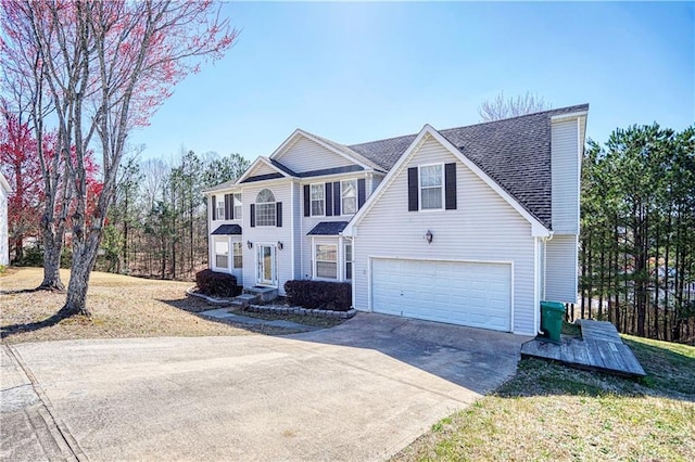 view of front of house featuring a garage, driveway, and a shingled roof