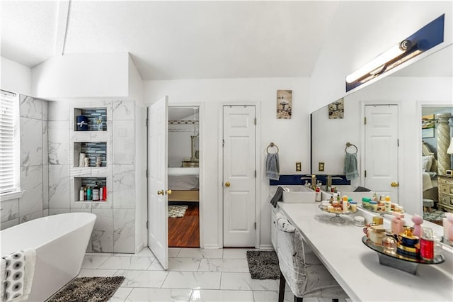 bathroom featuring vaulted ceiling, ensuite bathroom, a soaking tub, marble finish floor, and vanity