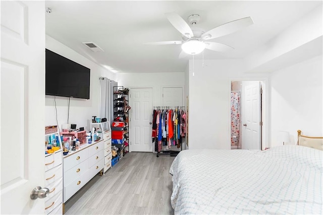 bedroom featuring light wood-type flooring, visible vents, and a ceiling fan