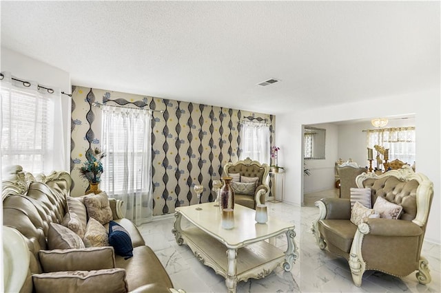 living room featuring visible vents, marble finish floor, and a textured ceiling