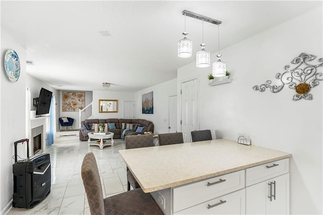 dining area featuring a fireplace and marble finish floor