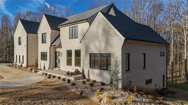 view of front of home with central AC and a patio