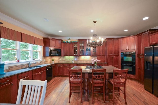 3423 Mulberry Lane Ct, Dacula, GA 30019 - kitchen featuring black appliances, light wood finished floors, a chandelier, crown molding, and glass insert cabinets