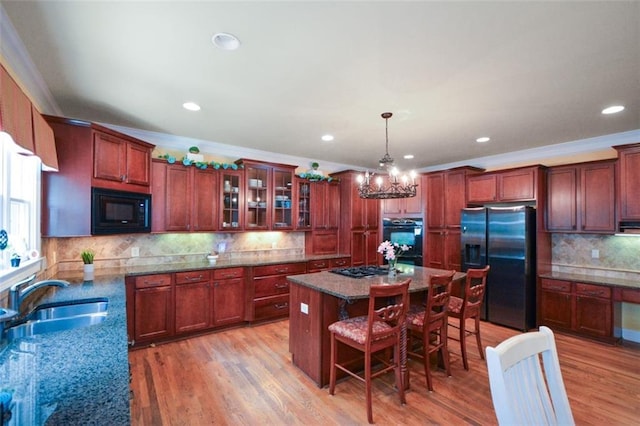 3423 Mulberry Lane Ct, Dacula, GA 30019 - kitchen with black appliances, backsplash, a kitchen island, a breakfast bar, and glass insert cabinets