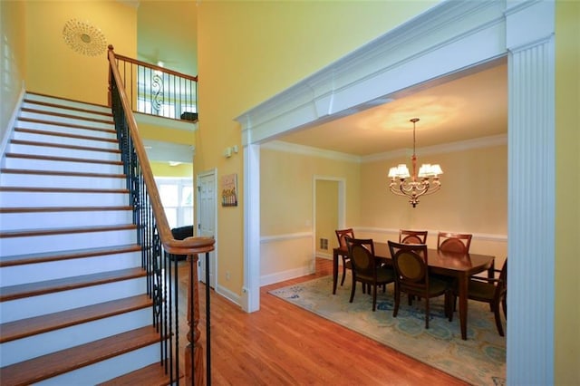 3423 Mulberry Lane Ct, Dacula, GA 30019 - dining room featuring stairs, wood finished floors, a chandelier, and crown molding