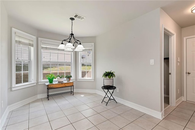 dining area featuring light tile patterned floors, a chandelier, and baseboards