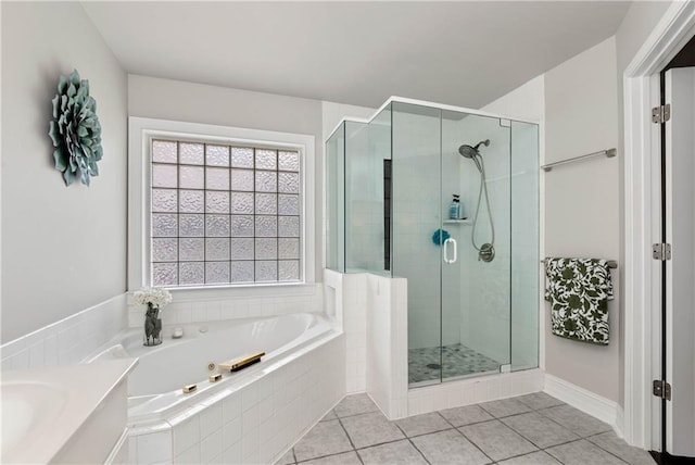 bathroom featuring a shower stall, a bath, and tile patterned flooring