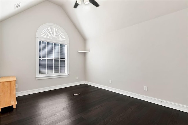 spare room featuring a ceiling fan, dark wood-type flooring, lofted ceiling, and baseboards