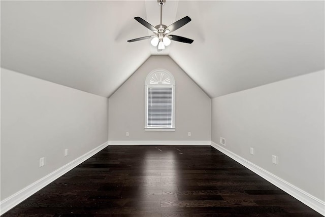 bonus room with dark wood-type flooring, a ceiling fan, vaulted ceiling, and baseboards