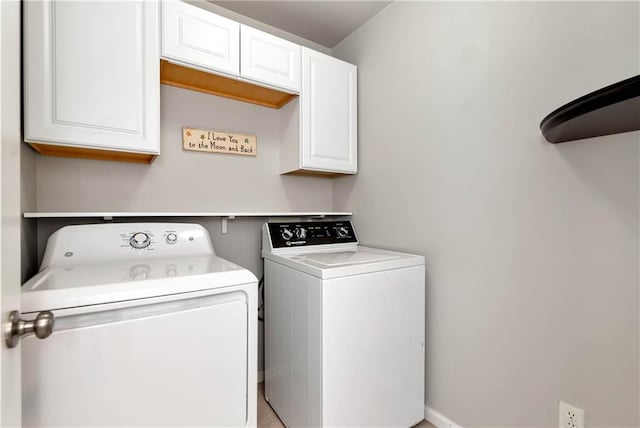laundry area featuring washing machine and clothes dryer and cabinet space
