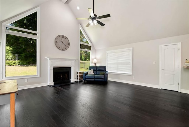 living area featuring a ceiling fan, wood finished floors, a fireplace with raised hearth, baseboards, and high vaulted ceiling
