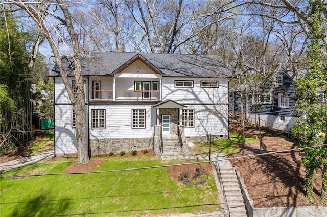 view of front of house featuring a balcony and a front yard