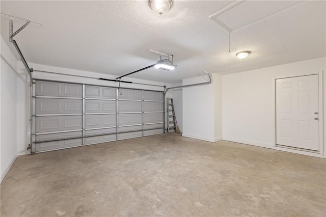 garage featuring a garage door opener and baseboards