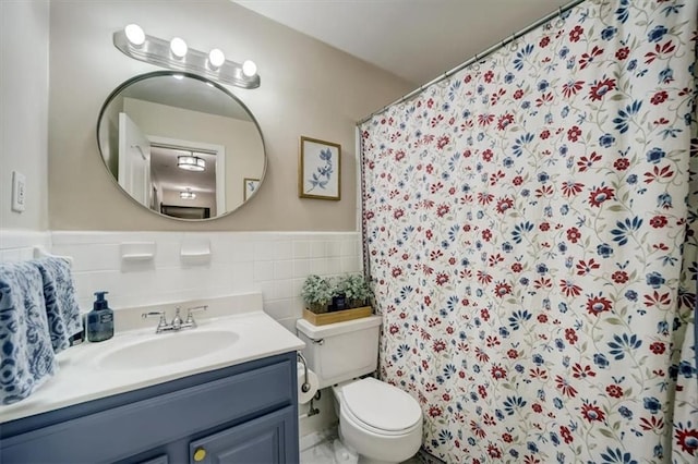 bathroom with vanity, toilet, curtained shower, and tile walls