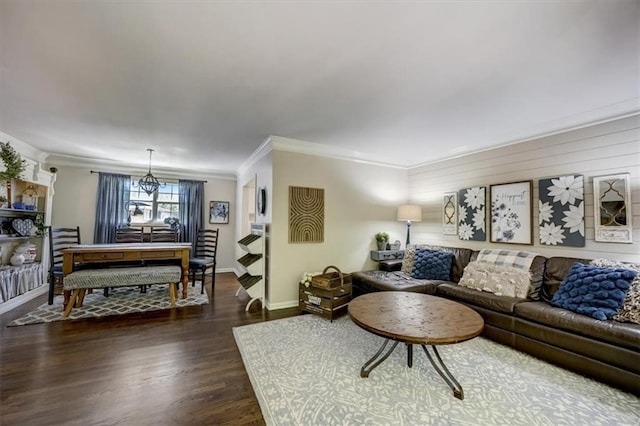 living room featuring dark hardwood / wood-style flooring, ornamental molding, and a chandelier