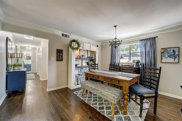 dining space with crown molding, dark wood-type flooring, and a notable chandelier