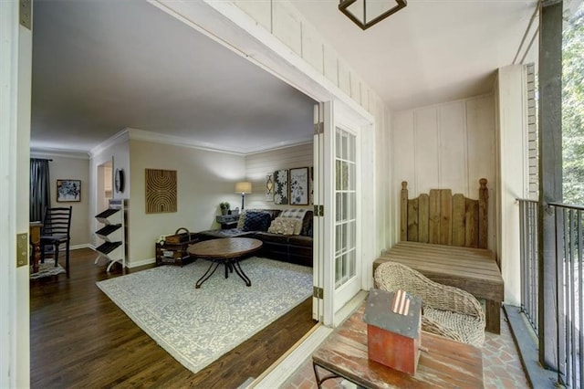 living area with wood-type flooring and ornamental molding