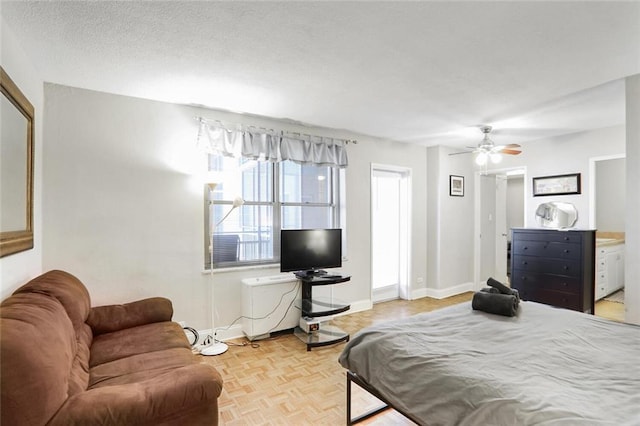 bedroom featuring light parquet floors, connected bathroom, a textured ceiling, and ceiling fan