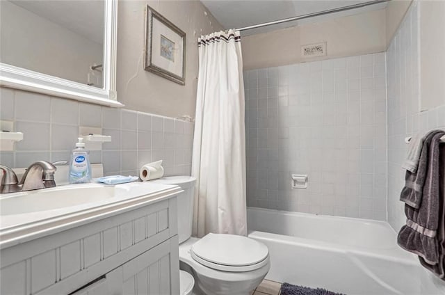 full bathroom featuring vanity, tile walls, shower / tub combo with curtain, and toilet