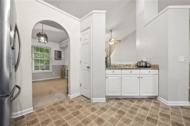 bathroom featuring vanity, ornamental molding, baseboards, and tile patterned floors