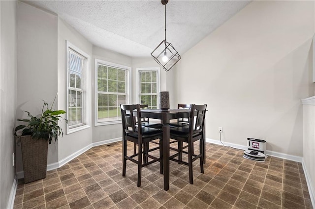 dining space with a textured ceiling and baseboards