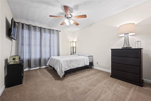 carpeted bedroom featuring a textured ceiling, baseboards, and a ceiling fan