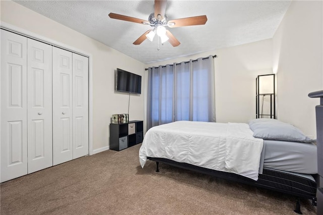 carpeted bedroom featuring a closet, a textured ceiling, baseboards, and a ceiling fan