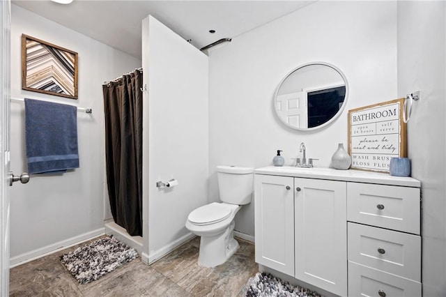 bathroom featuring toilet, curtained shower, baseboards, and vanity